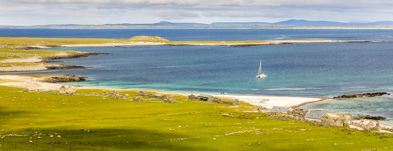 Ein magischer Ort - Inishkea-Island, Irland. Foto: Gerald Winkler Grüne Küste mit ankernder Yacht
